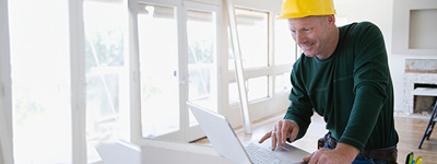 trade ally using a laptop in a bright construction site